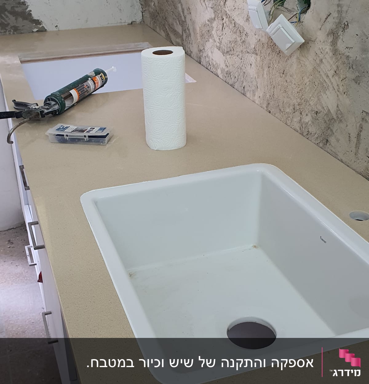 כיור לבן מותקן על משטח שיש במטבח